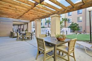 un patio con tavolo e sedie in legno di Homewood Suites by Hilton Palm Desert a Palm Desert