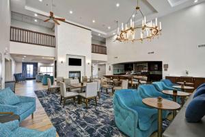 a hotel lobby with blue chairs and tables at Homewood Suites by Hilton Palm Desert in Palm Desert