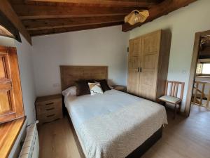 1 dormitorio con 1 cama grande y 1 silla en Cabaña Pasiega Montes del Pas, 