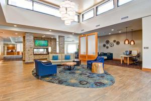 um átrio com cadeiras azuis, um sofá e uma mesa em Homewood Suites by Hilton Seattle-Issaquah em Issaquah