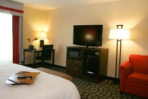 Habitación de hotel con cama y TV de pantalla plana. en Hampton Inn & Suites Salt Lake City-University/Foothill Drive, en Salt Lake City