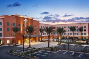 un grande edificio con palme in un parcheggio di Homewood Suites By Hilton Irvine John Wayne Airport a Irvine