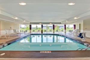 a swimming pool in a hotel with tables and chairs at Homewood Suites By Hilton Ottawa Kanata in Ottawa