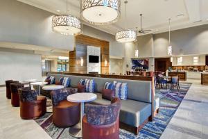 eine Lobby mit einem Sofa, Tischen und einer Bar in der Unterkunft Homewood Suites By Hilton Ottawa Kanata in Ottawa
