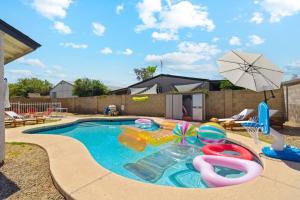 a swimming pool with a pool noodle raft at Eclectic Pool Ping-Pong Fire Pit 3 BR in Peoria