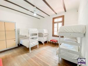 a room with four bunk beds and a window at Barcelona Hostel in Mar del Plata