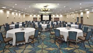 una sala banchetti con tavoli, sedie e schermo di DoubleTree by Hilton Hotel & Conference Centre Regina a Regina