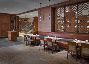 um restaurante com mesas e cadeiras e uma escadaria em DoubleTree by Hilton Hotel & Conference Centre Regina em Regina