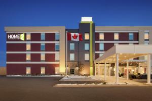 un edificio con una bandera canadiense delante de él en Home2 Suites by Hilton Fort St. John en Fort Saint John