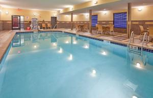 ein großer Pool in einem Hotel mit Tischen und Stühlen in der Unterkunft Hampton Inn & Suites Dickinson ND in Dickinson