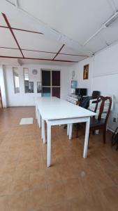 duży biały stół w pokoju z krzesłami w obiekcie Residencial familiar El Valle w mieście Copiapó