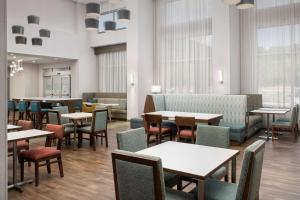 - une salle à manger avec des tables, des chaises et des fenêtres dans l'établissement Hampton Inn & Suites Lexington, à Lexington