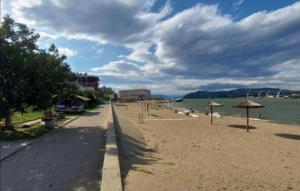 a sandy beach with umbrellas and the water at Apartman studio Oranž in Kladovo