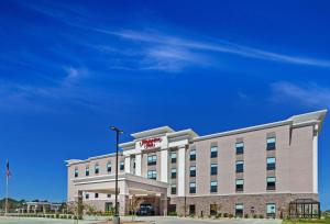 奥佐纳Hampton Inn Ozona的一座酒店大楼，楼顶有招牌