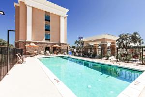 a swimming pool at a hotel with a building at Hampton Inn Ozona in Ozona