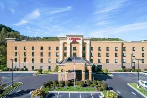 a large tan building with a flag in front of it at Hampton Inn University Area, Huntington, Wv in Huntington