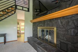 a living room with a stone fireplace in a house at Modern, Sleeps 6, Amazing Views in Maggie Valley