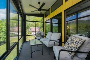 a screened in porch with two chairs and a table at Modern, Sleeps 6, Amazing Views in Maggie Valley