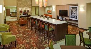 a hotel lobby with a bar and chairs at Hampton Inn & Suites Pittsburgh Waterfront West Homestead in West Homestead