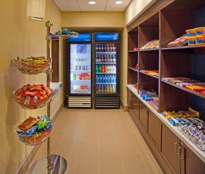 a store aisle with a refrigerator with drinks in it at Hampton Inn & Suites Pittsburgh Waterfront West Homestead in West Homestead