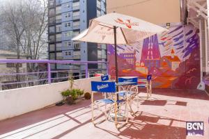 Barcelona Hostel في مار ديل بلاتا: طاولة وكراسي ومظلة على السطح