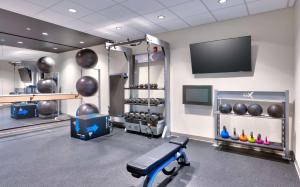 a gym with a bench and a flat screen tv at Tru By Hilton St. George in St. George