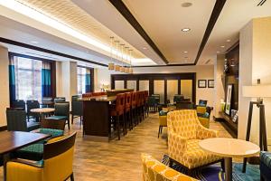 restauracja ze stołami i krzesłami oraz bar w obiekcie Hampton Inn by Hilton Ottawa Airport w mieście Ottawa