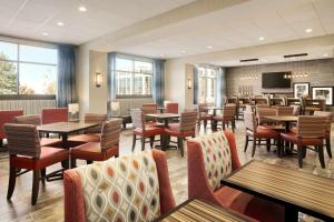 a restaurant with tables and chairs and a tv at Hampton Inn Salt Lake City Cottonwood in Holladay