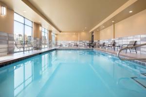 - une grande piscine avec des chaises dans un bâtiment dans l'établissement Hampton Inn Salt Lake City Cottonwood, à Holladay