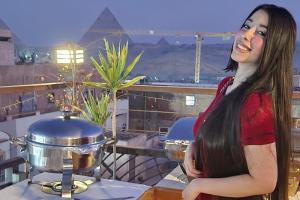 a woman standing next to a pot on a table at Le Riad Giza Pyramids Hotel in Cairo