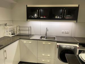 uma cozinha com armários brancos e uma máquina de lavar roupa em Big flat Brest em Brest