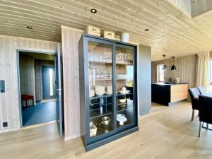 a room with a glass cabinet with dishes on it at Sunset Panorama - Superior Cabin Lofoten in Sand