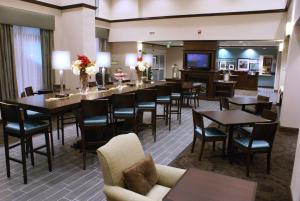 a restaurant with tables and chairs and a television at Hampton Inn & Suites Suisun City Waterfront in Suisun City