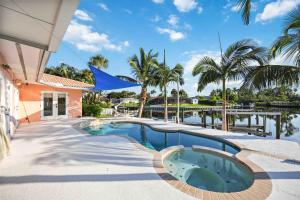 uma piscina ao lado de uma casa com palmeiras em Experience the Ultimate Waterfront Getaway! em Bradenton