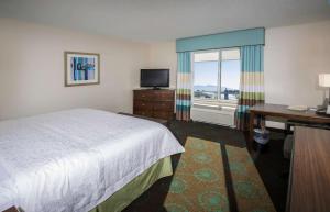 a hotel room with a bed and a desk and a window at Hampton Inn & Suites Suisun City Waterfront in Suisun City +25 photos