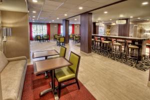 a hotel lobby with a bar and tables and chairs at Hampton Inn Cookeville in Cookeville