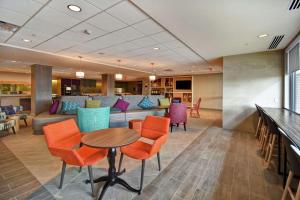 a lobby with a couch and a table and chairs at Home2 Suites By Hilton Amherst Buffalo in Amherst