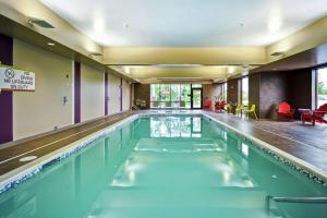 a swimming pool with blue water in a building at Home2 Suites By Hilton Amherst Buffalo in Amherst