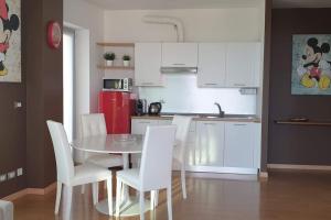 una cucina con tavolo, sedie e frigorifero rosso di Suite chocolat a Cuneo