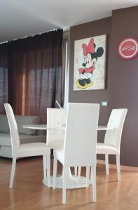 una sala da pranzo con tavolo e sedie bianchi di Suite chocolat a Cuneo