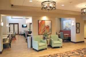uma sala de espera num hospital com cadeiras e mesas em Hampton Inn Cape Girardeau I-55 East, MO em Cape Girardeau