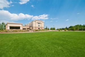 a large grass field in front of a building at Hampton Inn & Suites Buffalo in Buffalo