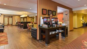 a lobby of a hotel with a waiting area with a counter at Hampton Inn Clinton in Clinton