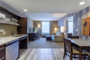 a kitchen and living room with a couch and a table at Home2 Suites Dover in Dover