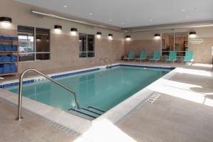 a pool in a hotel room with blue chairs at Home2 Suites By Hilton Denver South Centennial Airport in Centennial