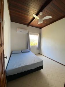 Schlafzimmer mit einem Bett und einem Deckenventilator in der Unterkunft Casa Cantinho de Arembepe - Linda casa com piscina no litoral norte da Bahia in Camaçari