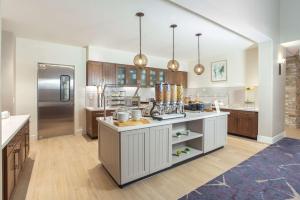 布鲁姆菲尔德Homewood Suites By Hilton Broomfield Boulder的一间大厨房,配有白色的橱柜和一台冰箱