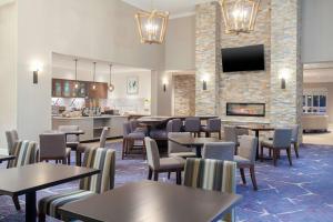 a restaurant with tables and chairs and a fireplace at Homewood Suites By Hilton Broomfield Boulder in Broomfield