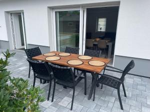 einen Holztisch und Stühle auf einer Terrasse in der Unterkunft Ferienhaus Helfert FeWo 1 in Niemtsch