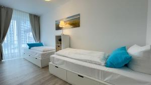1 dormitorio con 2 camas y ventana en Strandhaus-Nordseebrandung-Fewo-A1-1, en Cuxhaven